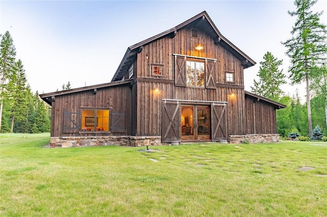 380 Haskill Basin Rd, Whitefish, MT 59937 - rear view of house featuring a barn, a yard, an outdoor structure, and board and batten siding