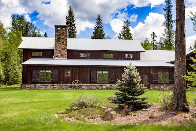 380 Haskill Basin Rd, Whitefish, MT 59937 - back of property featuring a lawn, a chimney, a metal roof, and a barn