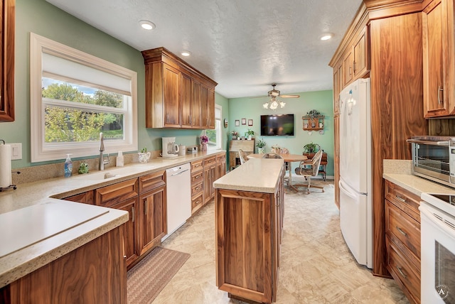 1502 Hauser Blvd, Helena, MT 59601 - kitchen featuring white appliances, a sink, a kitchen island, a ceiling fan, and light countertops