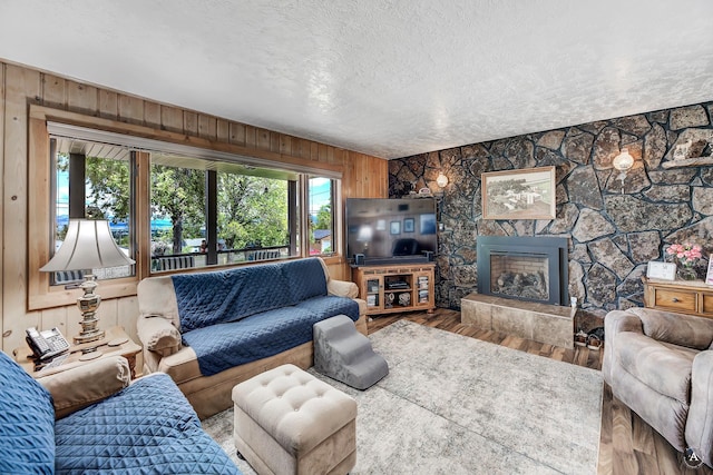 1502 Hauser Blvd, Helena, MT 59601 - living room with a textured ceiling, wood finished floors, wooden walls, and a stone fireplace