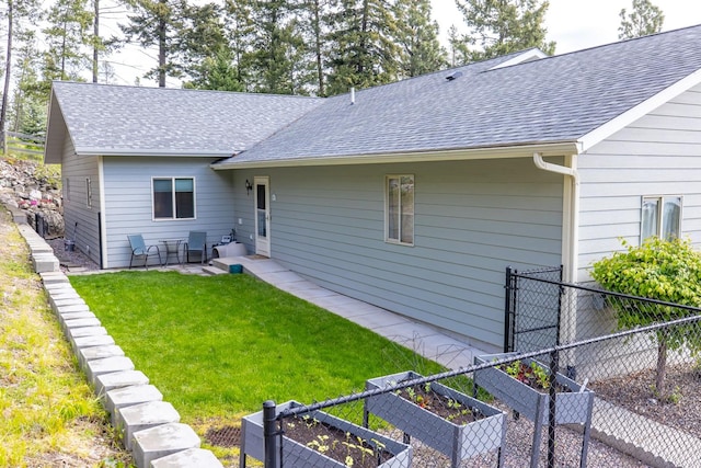 100 Rimini Rd, Lakeside, MT 59922 - rear view of house with a vegetable garden and roof with shingles