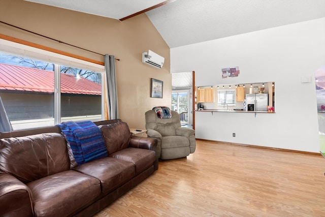 1509 Eagle Dr, Kalispell, MT 59901 - living area featuring a wall mounted AC, light wood finished floors, high vaulted ceiling, and baseboards
