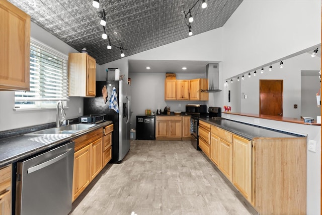 1509 Eagle Dr, Kalispell, MT 59901 - kitchen featuring stainless steel appliances, wall chimney range hood, a sink, rail lighting, and dark countertops