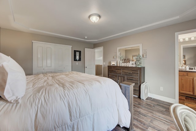 1150 Vega Rd, Helena, MT 59602 - bedroom featuring dark wood-style floors, baseboards, connected bathroom, and a closet