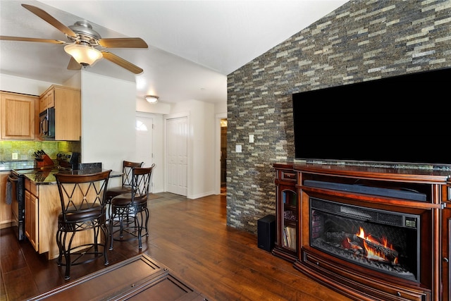1 Kootenai Ave Unit 17, Polson, MT 59860 - living area featuring lofted ceiling, a ceiling fan, dark wood-style floors, and a lit fireplace