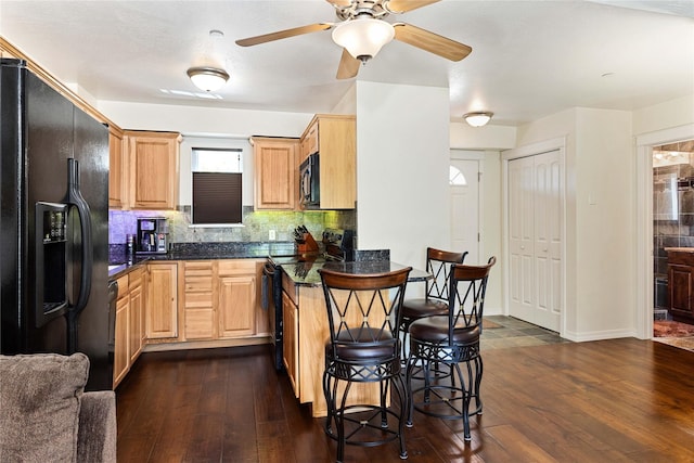 1 Kootenai Ave Unit 17, Polson, MT 59860 - kitchen featuring black appliances, dark countertops, a kitchen breakfast bar, and dark wood-style flooring