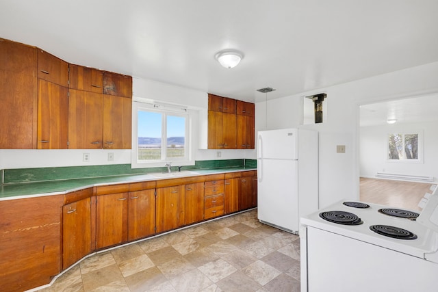 1680 W River Rd, Deer Lodge, MT 59722 - kitchen with white appliances, brown cabinets, a sink, light countertops, and stone finish flooring