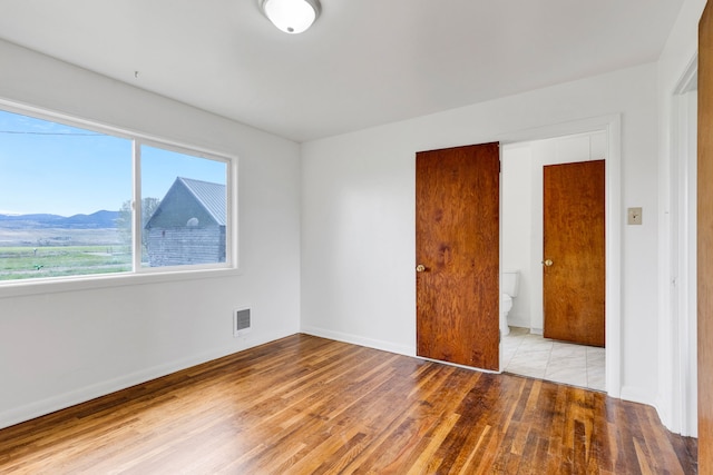 1680 W River Rd, Deer Lodge, MT 59722 - spare room with light wood finished floors, a mountain view, and baseboards