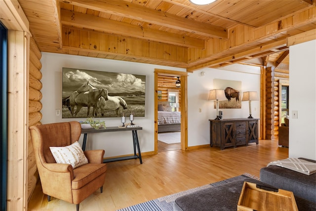 1266 Ousel Falls Rd, Big Sky, MT 59716 - living area with log walls, wooden ceiling with exposed beams, wood finished floors, and baseboards