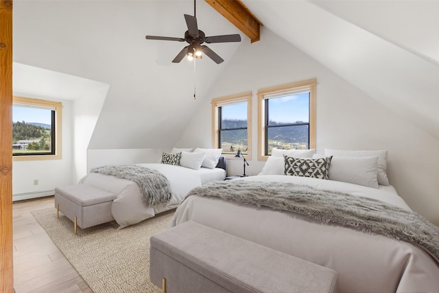 1266 Ousel Falls Rd, Big Sky, MT 59716 - bedroom featuring multiple windows, a baseboard radiator, light wood finished floors, and a ceiling fan