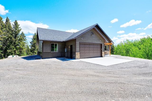 115 Grassy Mountain Rd, White Sulphur Springs, MT 59645 - view of front of home with concrete driveway, an attached garage, stone siding, and roof with shingles