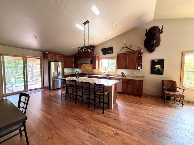 115 Grassy Mountain Rd, White Sulphur Springs, MT 59645 - kitchen featuring stainless steel appliances, wall chimney range hood, hardwood / wood-style floors, a sink, and a kitchen island with sink