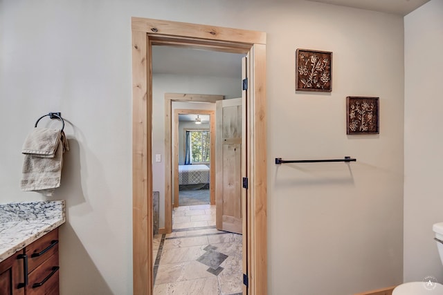 115 Grassy Mountain Rd, White Sulphur Springs, MT 59645 - bathroom featuring vanity, toilet, baseboards, and stone tile floors
