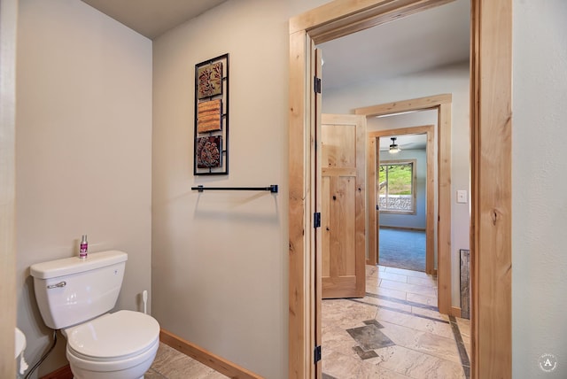 115 Grassy Mountain Rd, White Sulphur Springs, MT 59645 - bathroom featuring baseboards, toilet, and stone tile floors