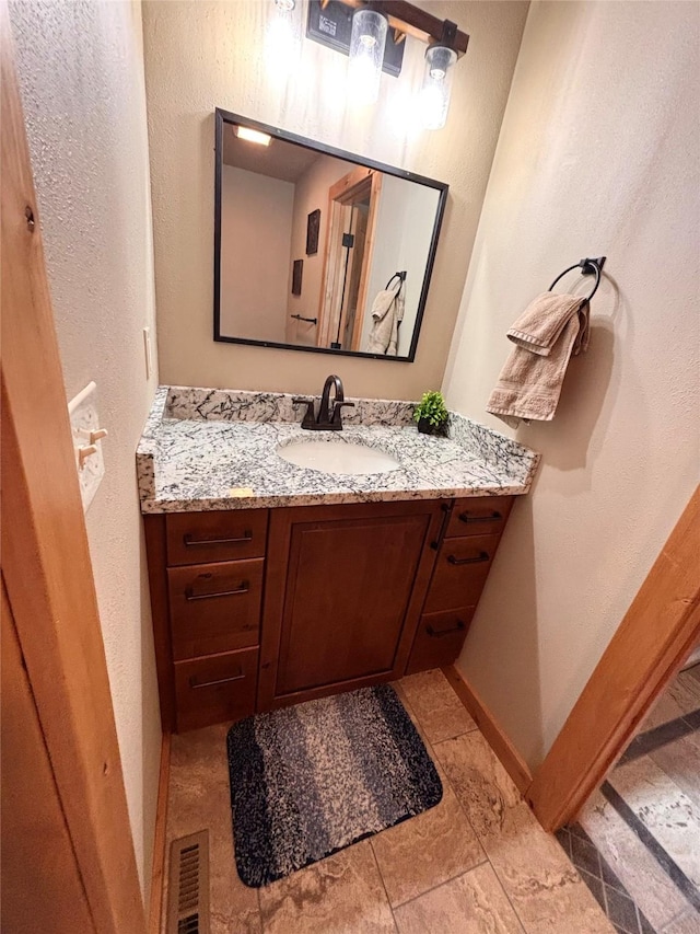 115 Grassy Mountain Rd, White Sulphur Springs, MT 59645 - bathroom featuring vanity, baseboards, and a textured wall