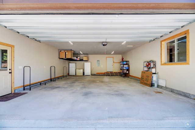 115 Grassy Mountain Rd, White Sulphur Springs, MT 59645 - garage with baseboards, a garage door opener, and freestanding refrigerator