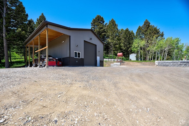 115 Grassy Mountain Rd, White Sulphur Springs, MT 59645 - view of side of property with a detached garage, an outbuilding, and dirt driveway