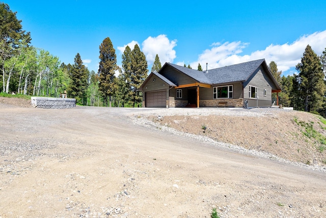 115 Grassy Mountain Rd, White Sulphur Springs, MT 59645 - view of front facade featuring stone siding, an attached garage, and dirt driveway