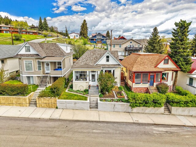 1147 W Woolman St, Butte, MT 59701 - view of front of property with a residential view, stairs, and roof with shingles