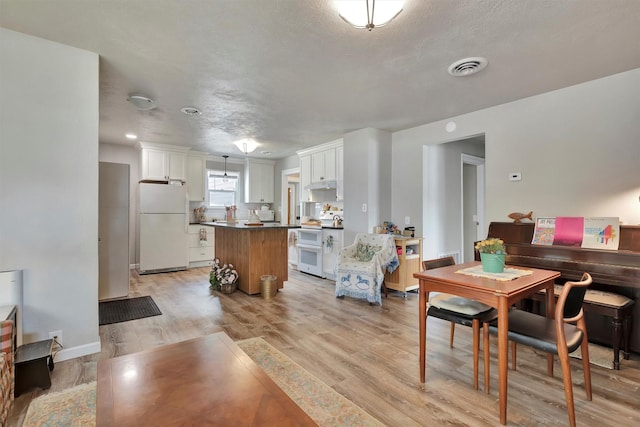 510 Mission St, Stevensville, MT 59870 - dining area featuring light wood-style floors, a textured ceiling, and baseboards