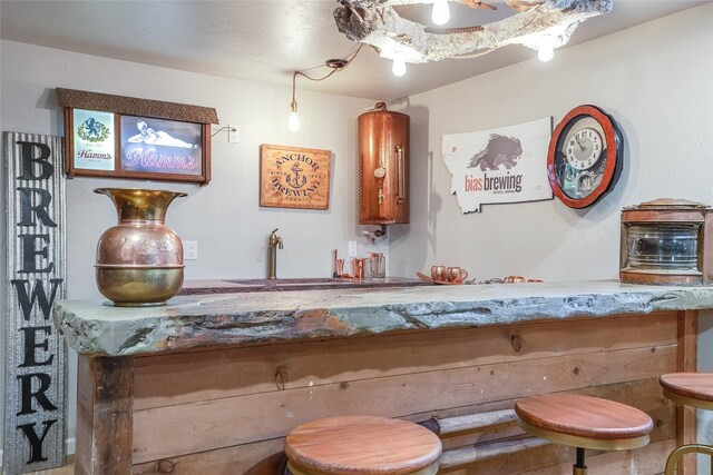 442 4th Ave E, Kalispell, MT 59901 - kitchen with concrete flooring, a peninsula, recessed lighting, a breakfast bar area, and baseboards