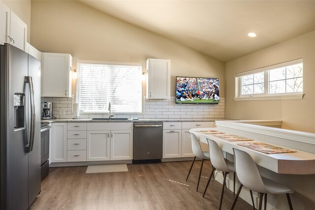 442 4th Ave E, Kalispell, MT 59901 - kitchen featuring appliances with stainless steel finishes, high vaulted ceiling, a sink, a ceiling fan, and decorative backsplash