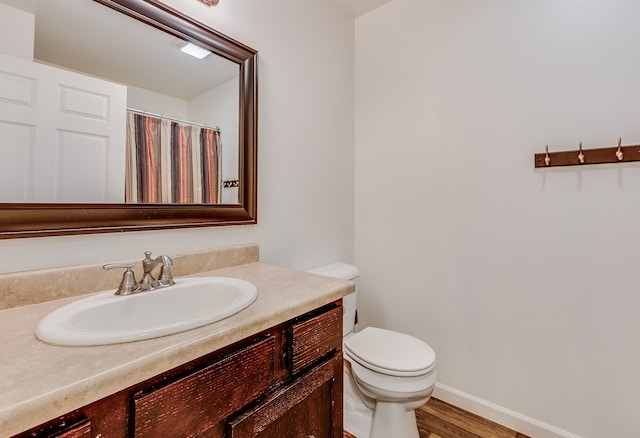 1126 Jordan Cir, Billings, MT 59105 - full bathroom with toilet, vanity, wood finished floors, and baseboards