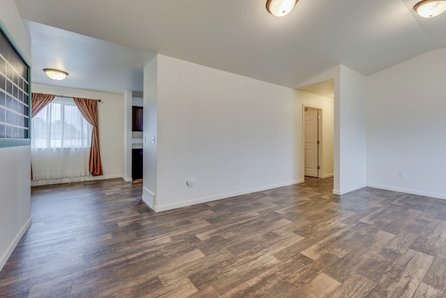 1126 Jordan Cir, Billings, MT 59105 - empty room featuring dark wood-style flooring, lofted ceiling, and baseboards