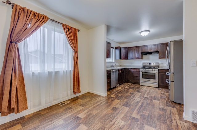 1126 Jordan Cir, Billings, MT 59105 - kitchen with appliances with stainless steel finishes, dark wood-style flooring, under cabinet range hood, light countertops, and dark brown cabinets