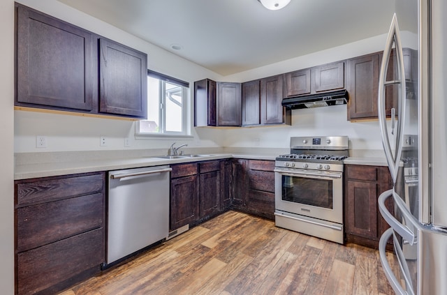 1126 Jordan Cir, Billings, MT 59105 - kitchen featuring stainless steel appliances, under cabinet range hood, a sink, light wood-type flooring, and light countertops