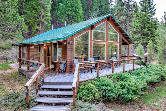 7990 W Fork Rd, Darby, MT 59829 - chalet / cabin featuring metal roof, a wooden deck, and a forest view