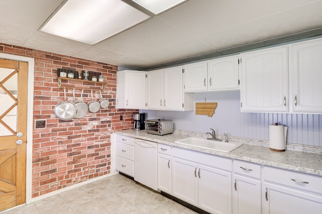 503 7th Ave W, Polson, MT 59860 - kitchen with a sink, brick wall, white dishwasher, white cabinetry, and light stone countertops
