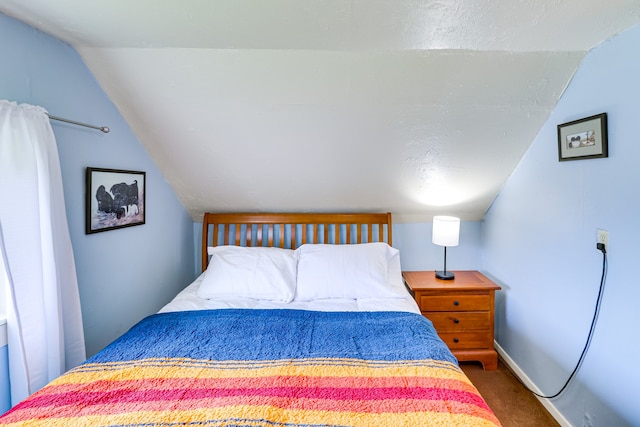 503 7th Ave W, Polson, MT 59860 - carpeted bedroom featuring vaulted ceiling and baseboards