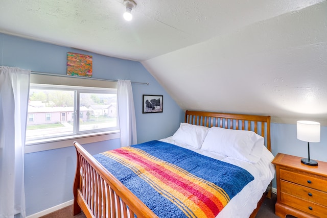 503 7th Ave W, Polson, MT 59860 - carpeted bedroom featuring vaulted ceiling, a textured ceiling, and baseboards