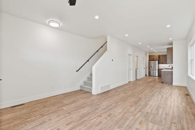 604 Holstein Way, Kalispell, MT 59901 - unfurnished living room with recessed lighting, light wood-type flooring, and stairs