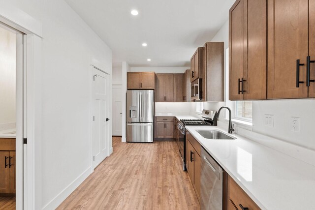 604 Holstein Way, Kalispell, MT 59901 - kitchen featuring appliances with stainless steel finishes, light wood finished floors, brown cabinetry, light countertops, and recessed lighting