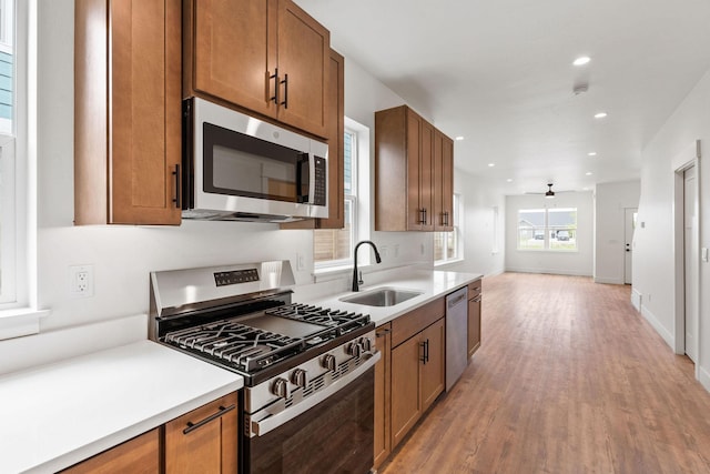 604 Holstein Way, Kalispell, MT 59901 - kitchen featuring stainless steel appliances, brown cabinetry, a ceiling fan, light wood-type flooring, and open floor plan