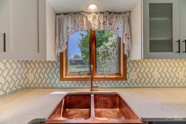 2685 Pinkerton Dr, East Helena, MT 59635 - kitchen with a sink, glass insert cabinets, decorative backsplash, white cabinetry, and light stone countertops