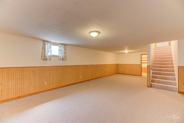 2685 Pinkerton Dr, East Helena, MT 59635 - below grade area with wainscoting, stairway, a textured ceiling, wooden walls, and carpet flooring