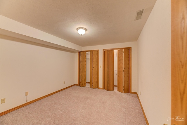 2685 Pinkerton Dr, East Helena, MT 59635 - unfurnished bedroom featuring multiple closets, light carpet, baseboards, and a textured ceiling