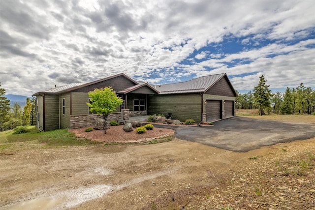 3525 Overland Rd, Helena, MT 59602 - view of front facade with a garage, metal roof, driveway, and stone siding
