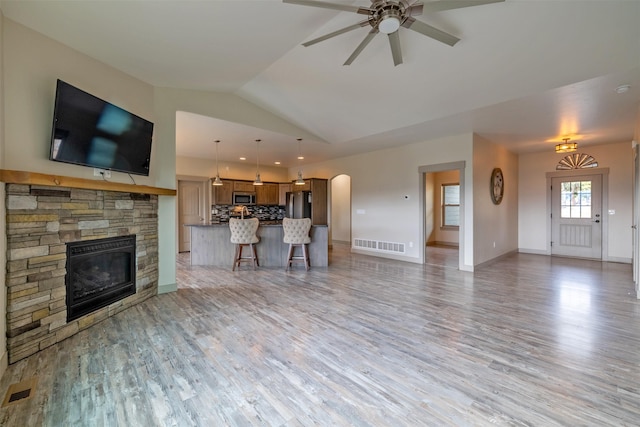 3525 Overland Rd, Helena, MT 59602 - living area with a stone fireplace, ceiling fan, light wood finished floors, lofted ceiling, and baseboards