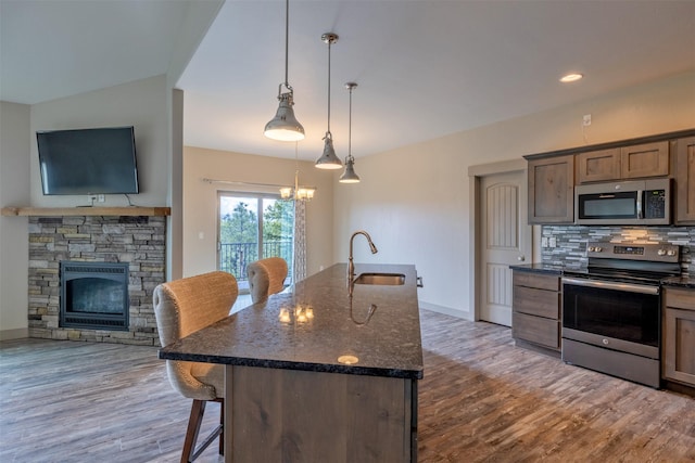 3525 Overland Rd, Helena, MT 59602 - kitchen with stainless steel appliances, a sink, a kitchen breakfast bar, wood finished floors, and backsplash