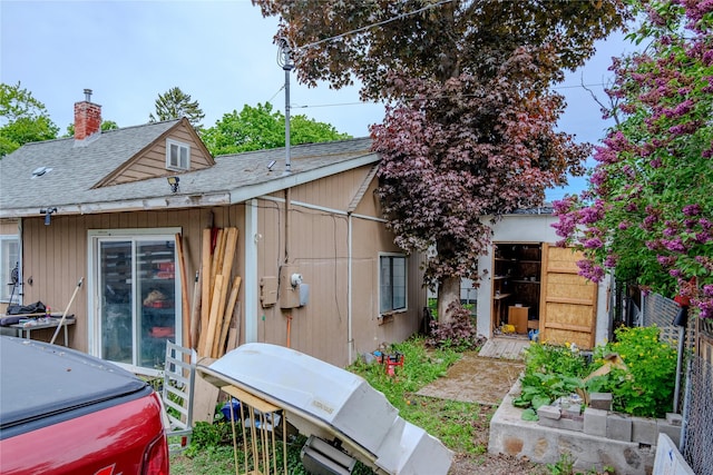 945 3rd Ave W, Kalispell, MT 59901 - view of side of home featuring a shingled roof and a chimney