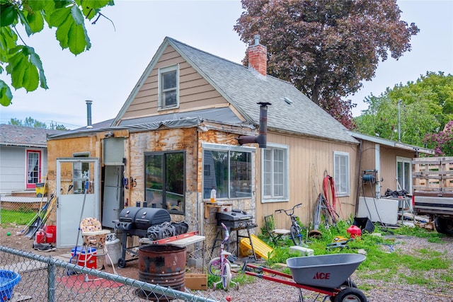 945 3rd Ave W, Kalispell, MT 59901 - back of property with a shingled roof and a chimney