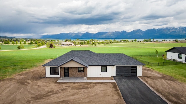 34544 Eagle Crest Dr, Polson, MT 59860 - view of front of property featuring an attached garage, asphalt driveway, a mountain view, a rural view, and roof with shingles