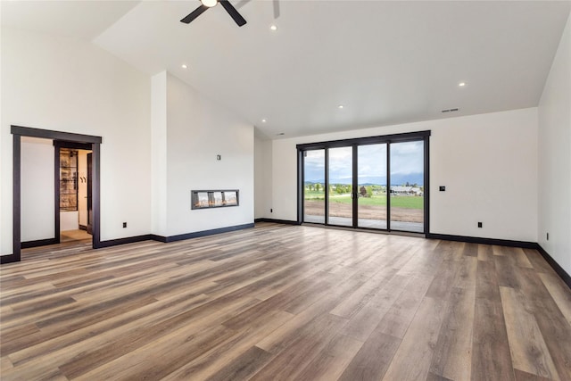 34544 Eagle Crest Dr, Polson, MT 59860 - unfurnished living room featuring a ceiling fan, wood finished floors, baseboards, high vaulted ceiling, and recessed lighting