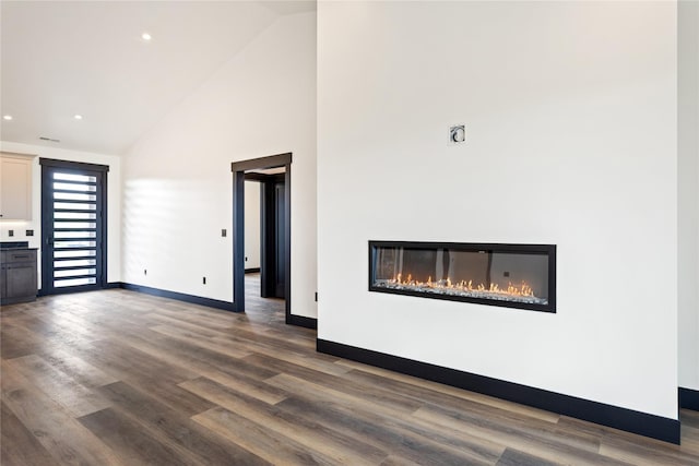 34544 Eagle Crest Dr, Polson, MT 59860 - unfurnished living room featuring high vaulted ceiling, a glass covered fireplace, dark wood finished floors, baseboards, and recessed lighting