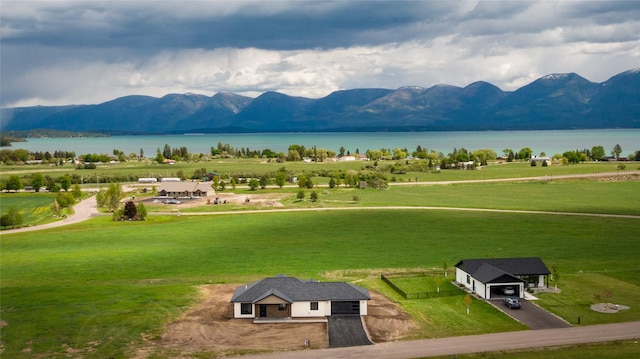 34544 Eagle Crest Dr, Polson, MT 59860 - view of property's community with a water and mountain view, driveway, a yard, and a garage