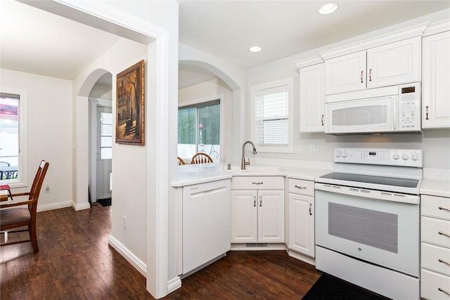 173 Empire Loop, Kalispell, MT 59901 - kitchen with white appliances, arched walkways, dark wood-type flooring, white cabinets, and healthy amount of natural light